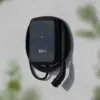 Elli Charger Connect 2 an einer hellen Hauswand mit aufgehängtem Ladekabel