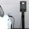EM2GO Standfuß PRO Power Single mit montierter PRO Power Wallbox, die ein weißes Auto lädt (Wallbox nicht im Lieferumfang)