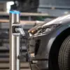 Hesotec eSat r10 aus Edelstahl lädt ein Elektroauto in einer Halle, das Ladekabel steckt in der Typ-2-Buchse der Säule