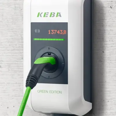 Nahansicht Keba KeContact P30 x-series: KEBA-Logo, rote Zähleranzeige und grüne LED-Leiste im dunklen Bedienfeld, darunter der eingesteckte Typ-2-Stecker in der Parkposition und der Schriftzug GREEN EDITION